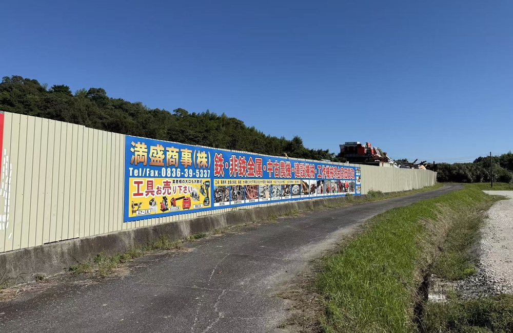満盛商事の看板と金属回収ヤード